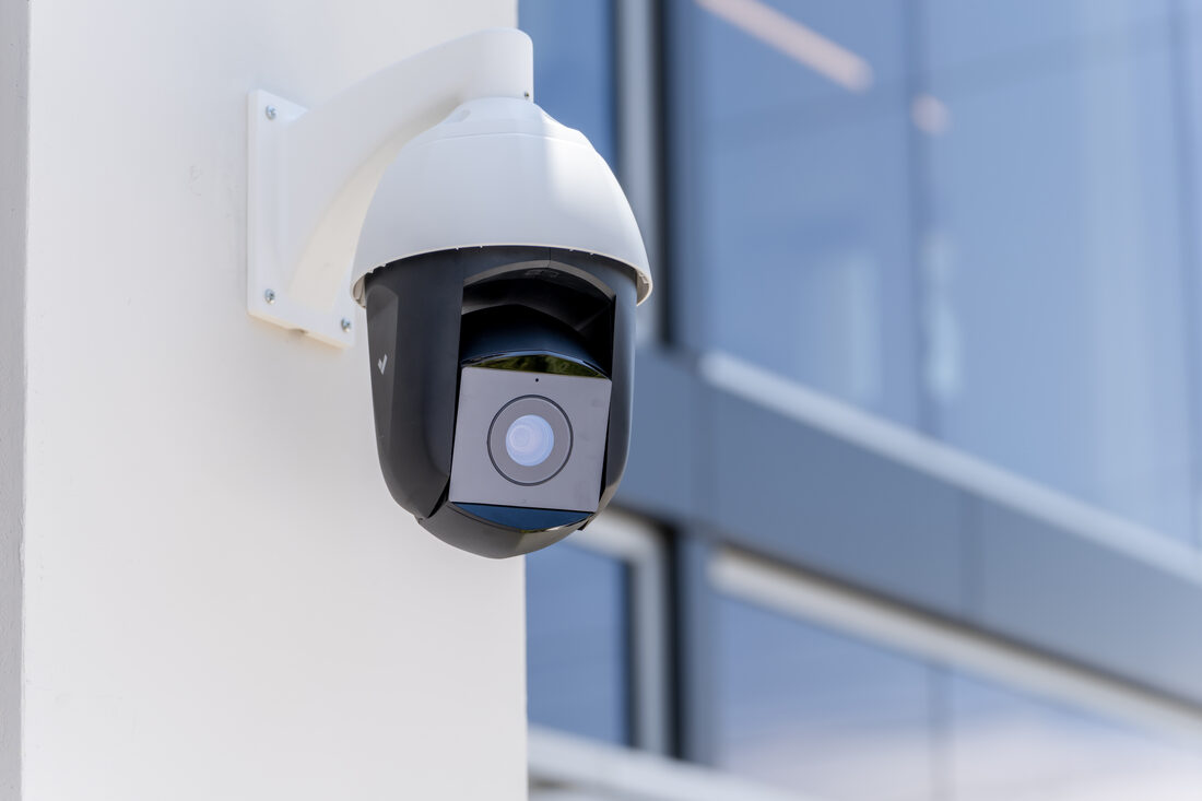 A pan-tilt-zoom camera on a glazed building